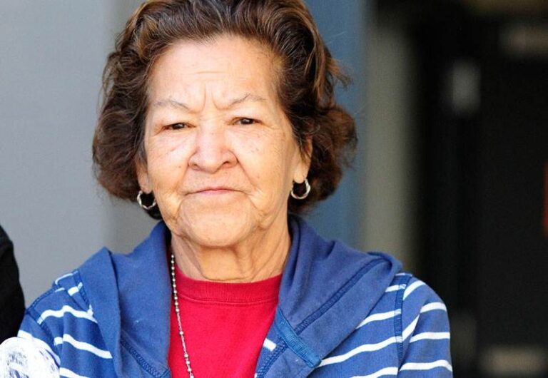 Elderly woman in blue-striped jacket outdoors